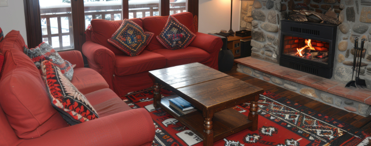 Room with two love seats, coffee table and rug in front of a fireplace 