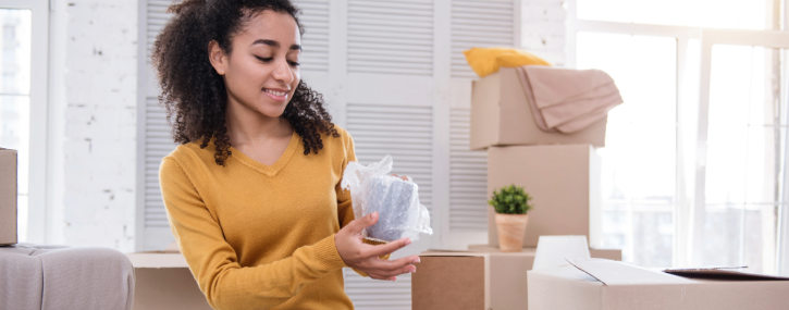 woman wrapping fragile items before placing them in a box