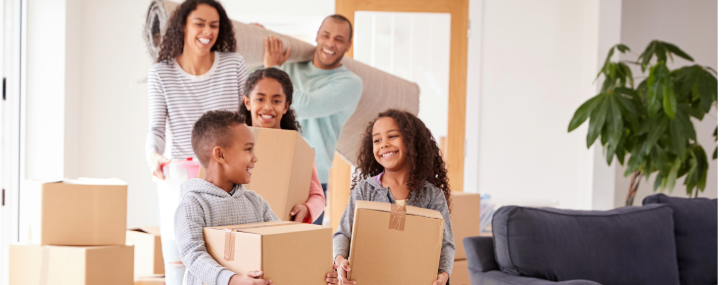 a family of five in a brightly lit room filled with boxes