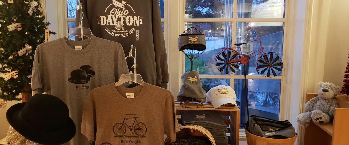 Display of Dayton-themed shirts, hats, souvenirs, and historical gifts inside the Carillon Historical Park Museum Store.